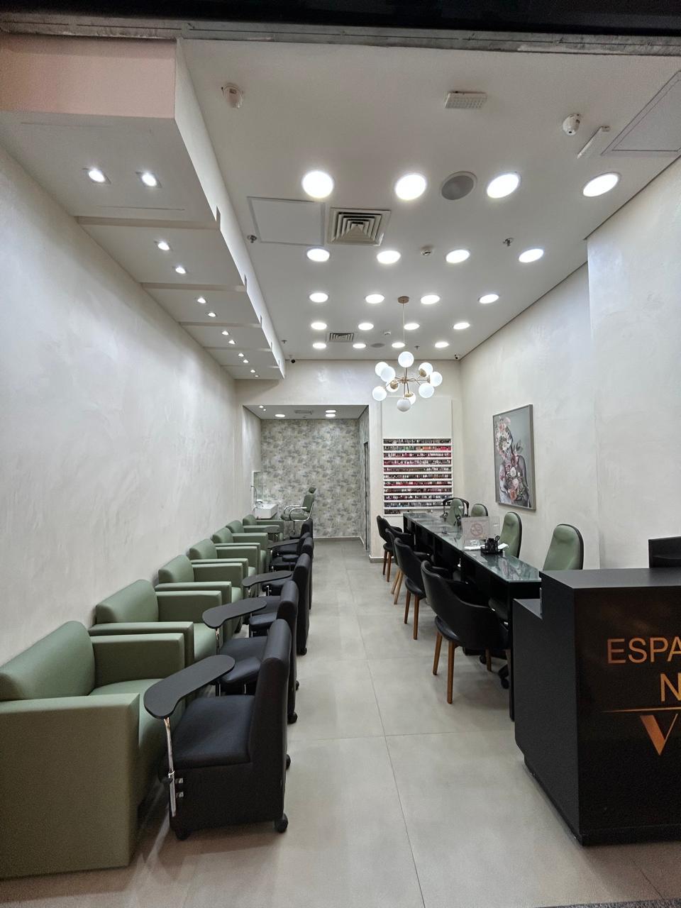 Salão da Andrea Ramos Esmalteria com poltronas em verde sage e balcão em preto e dourado